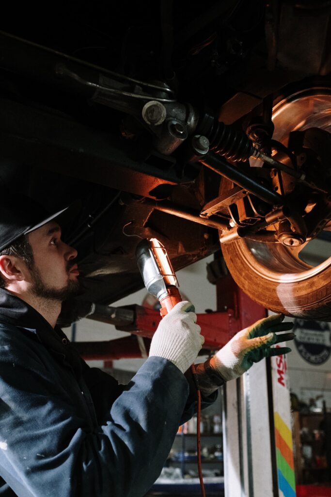 man inspecting underside of car